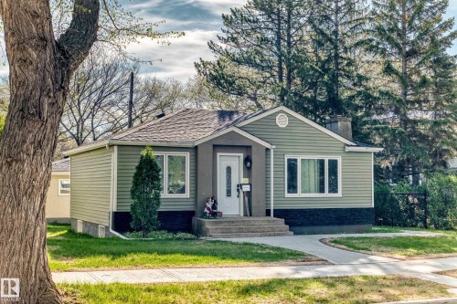 Siding exterior with a covered porch entry, concrete steps, and a curved walkway - 11303 60 Street, Edmonton, AB - Outdoor