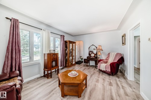 Living room featuring light wood-finish flooring, light grey wall paint, and white trim - 11303 60 Street, Edmonton, AB - Indoor Photo Showing Other Room