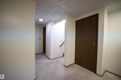 Interior hallway featuring light-colored walls and dark wood-finish doors - 4724 38B Avenue Nw, Edmonton, AB - Indoor Photo Showing Other Room