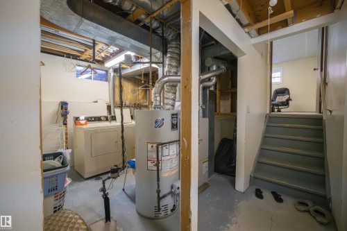 Basement utility area featuring a washer, dryer, water heater, and furnace - 4724 38B Avenue Nw, Edmonton, AB - Indoor Photo Showing Basement