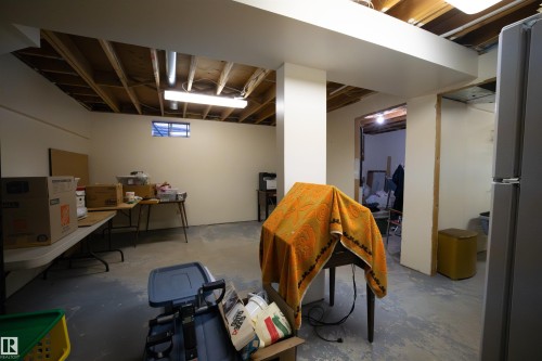 Basement area featuring exposed ceiling joists and structural beams, painted perimeter walls, a window opening, and a concrete floor - 4724 38B Avenue Nw, Edmonton, AB - Indoor Photo Showing Basement