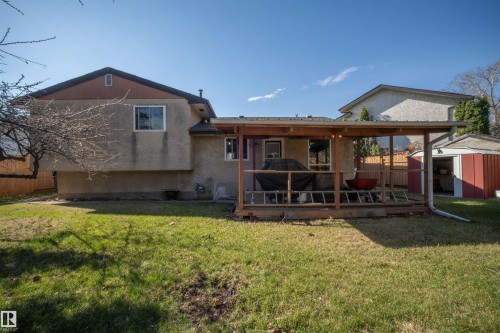 Expansive backyard featuring a covered deck, substantial lawn area, and a detached storage shed - 4724 38B Avenue Nw, Edmonton, AB - Outdoor