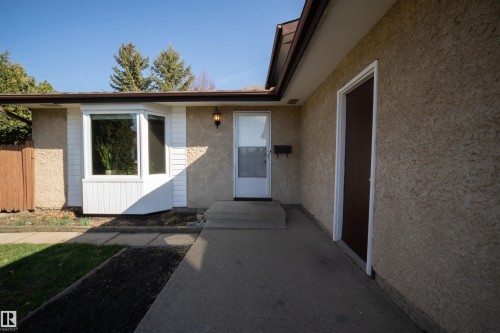 Stucco exterior with a bay window featuring white siding and trim - 4724 38B Avenue Nw, Edmonton, AB - Outdoor With Exterior
