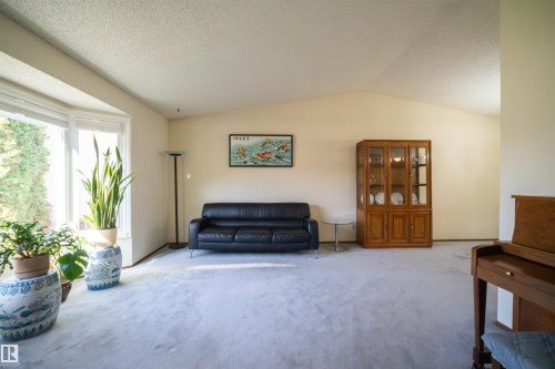 Spacious living area featuring a large bay window, vaulted ceilings, and light-toned carpeting - 4724 38B Avenue Nw, Edmonton, AB - Indoor Photo Showing Living Room