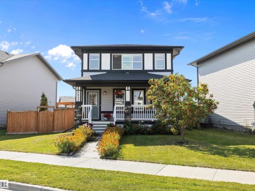 The property features a two-story exterior with light gray siding and dark trim, highlighted by white window frames - 9852 217 Street, Edmonton, AB - Outdoor With Deck Patio Veranda