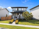 The property features a two-story exterior with light gray siding and dark trim, highlighted by white window frames - 9852 217 Street, Edmonton, AB  - Outdoor With Deck Patio Veranda 