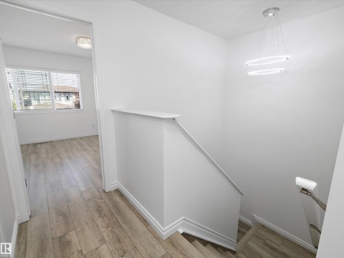 The property features light-toned wood flooring throughout, white walls, and white baseboards - 9852 217 Street, Edmonton, AB - Indoor Photo Showing Other Room