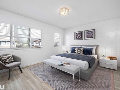 This inviting room features light wood-style flooring, white walls, and bright windows with blinds - 9852 217 Street, Edmonton, AB - Indoor Photo Showing Bedroom