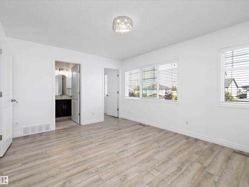Spacious room featuring light-toned flooring, white walls, and bright windows with blinds - 9852 217 Street, Edmonton, AB - Indoor Photo Showing Other Room