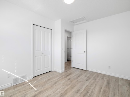 This room features a light-colored wood-look floor, white walls, and white trim - 9852 217 Street, Edmonton, AB - Indoor Photo Showing Other Room