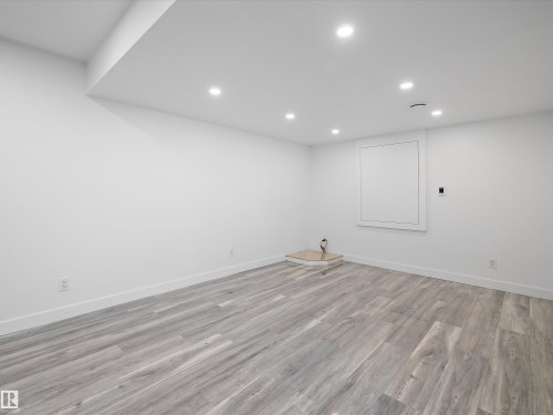 Spacious room with light-toned wood flooring, recessed lighting, and white walls - 9852 217 Street, Edmonton, AB - Indoor Photo Showing Other Room