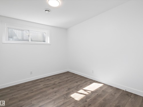 Room featuring light wood-style flooring and a window with horizontal blinds - 9852 217 Street, Edmonton, AB - Indoor Photo Showing Other Room