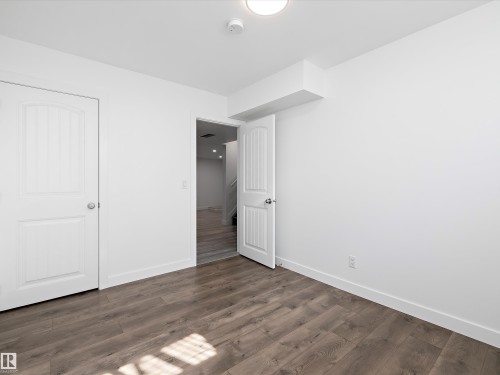 Room featuring light-colored walls, wood-style flooring, and white interior doors - 9852 217 Street, Edmonton, AB - Indoor Photo Showing Other Room