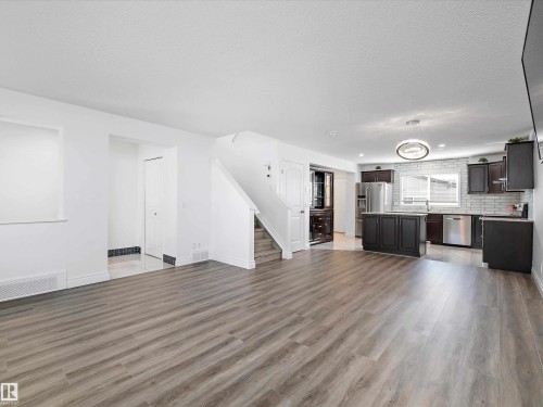 Open concept living space featuring wide plank flooring, white walls, and a modern kitchen - 9852 217 Street, Edmonton, AB - Indoor Photo Showing Kitchen