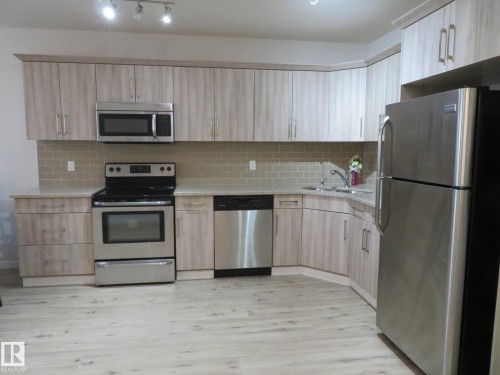 Kitchen featuring light wood-finish cabinetry, stainless steel appliances, speckled countertops, and a subway tile backsplash - 11840B 122 Street, Edmonton, AB - Indoor Photo Showing Kitchen With Stainless Steel Kitchen