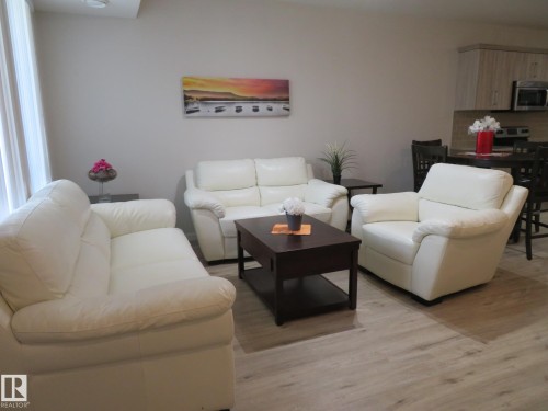 Open-concept living space featuring light wood-finish flooring, recessed ceiling lighting, and a white wall finish - 11840B 122 Street, Edmonton, AB - Indoor Photo Showing Living Room
