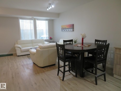 Open-concept living space featuring wood-finish flooring, recessed lighting, and ample natural light from multiple windows - 11840B 122 Street, Edmonton, AB - Indoor Photo Showing Dining Room