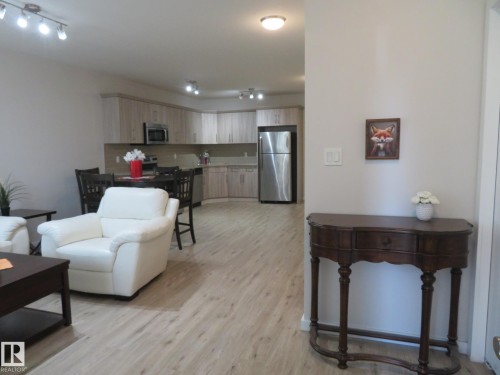 Open-concept living space featuring wood-finish flooring, recessed lighting, and track lighting - 11840B 122 Street, Edmonton, AB - Indoor