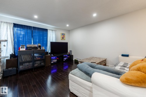 Spacious living area featuring dark wood-finish flooring, recessed lighting, and ample wall space - 3004 68 Street, Edmonton, AB - Indoor