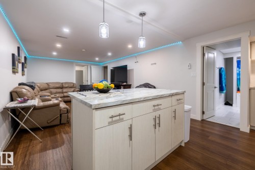Kitchen island with stone-look countertop and under-cabinet storage - 3004 68 Street, Edmonton, AB - Indoor Photo Showing Other Room