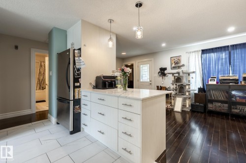 Kitchen island featuring a white countertop with integrated storage drawers - 3004 68 Street, Edmonton, AB - Indoor Photo Showing Kitchen