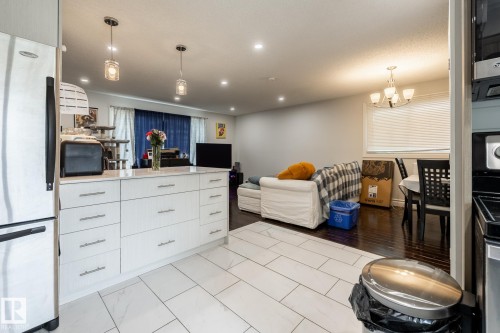 Modern kitchen island with white cabinetry and a light-toned countertop - 3004 68 Street, Edmonton, AB - Indoor