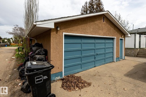 Detached garage featuring a paneled overhead door, a pedestrian door, and stucco exterior - 3004 68 Street, Edmonton, AB - Outdoor With Exterior
