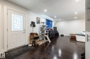 Entryway with a white paneled door featuring decorative glass, dark wood-finish flooring, recessed ceiling lighting, and white baseboards - 3004 68 Street, Edmonton, AB  - Indoor Photo Showing Other Room 