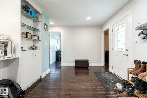 Entryway featuring rich wood-finish flooring and a white front door with decorative glass inserts - 3004 68 Street, Edmonton, AB - Indoor Photo Showing Other Room