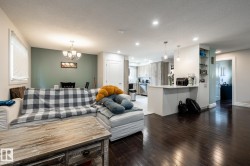 Open-concept living space with dark wood-finish flooring - 