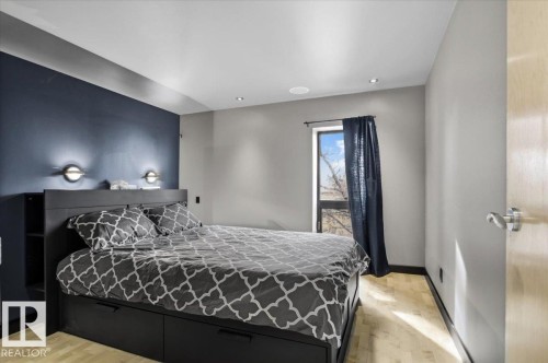 Bedroom featuring light wood-finish flooring, recessed ceiling lighting, and a contrasting accent wall - 8709 92A Avenue, Edmonton, AB - Indoor Photo Showing Bedroom