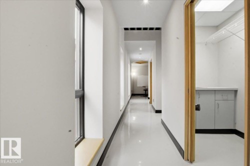 Bright hallway with glossy white flooring, recessed lighting, and multiple windows with wood sills - 8709 92A Avenue, Edmonton, AB - Indoor Photo Showing Other Room
