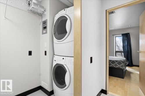 Dedicated laundry area featuring stacked front-load washer and dryer units - 8709 92A Avenue, Edmonton, AB - Indoor Photo Showing Laundry Room