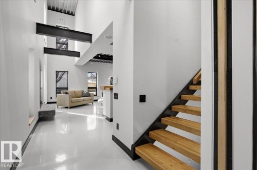 Floating wood staircase with open risers and black metal stringers - 8709 92A Avenue, Edmonton, AB - Indoor Photo Showing Other Room