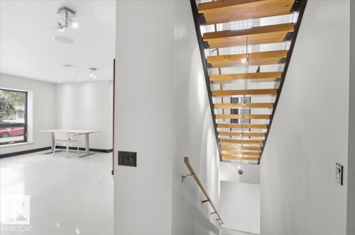 Modern open-riser staircase with wood treads and a metal frame - 8709 92A Avenue, Edmonton, AB - Indoor Photo Showing Other Room