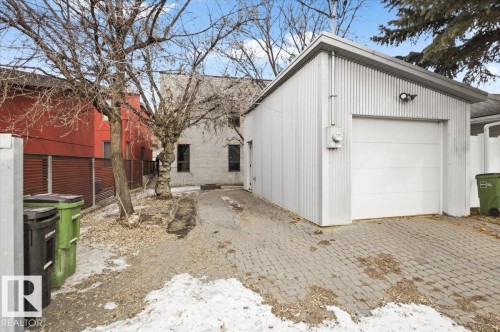 Detached garage with corrugated metal siding and a white sectional overhead door - 8709 92A Avenue, Edmonton, AB - Outdoor With Exterior