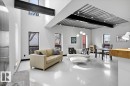 Spacious living area featuring polished concrete flooring, exposed structural beams, high ceilings, and multiple windows - 8709 92A Avenue, Edmonton, AB  - Indoor Photo Showing Living Room 