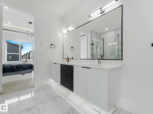 Dual vanity with white cabinetry and dark accent drawers, topped with light countertops - 16307 19 Avenue, Edmonton, AB - Indoor Photo Showing Bathroom