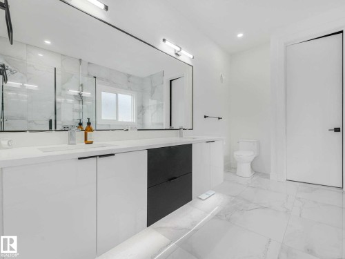 Double vanity with integrated sinks and white countertops - 16307 19 Avenue, Edmonton, AB - Indoor Photo Showing Bathroom