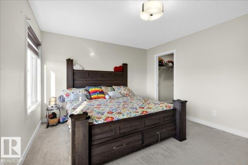Carpeted room featuring a white window frame, light-colored walls, and a ceiling-mounted light fixture - 5315 22 Avenue, Edmonton, AB - Indoor Photo Showing Bedroom