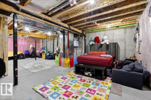 Unfinished basement space featuring exposed wooden joists, concrete foundation walls, and concrete flooring - 5315 22 Avenue, Edmonton, AB - Indoor Photo Showing Basement