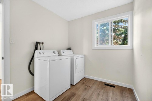 Dedicated laundry area featuring wood-finish flooring and a white-framed window - 32 1820 56 Street, Edmonton, AB - Indoor Photo Showing Laundry Room