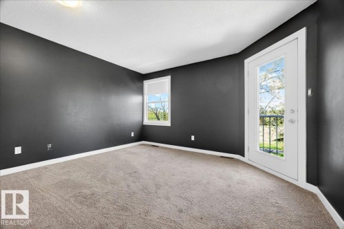 Room featuring dark-toned walls, light carpeting, white trim, and a ceiling light fixture - 32 1820 56 Street, Edmonton, AB - Indoor Photo Showing Other Room