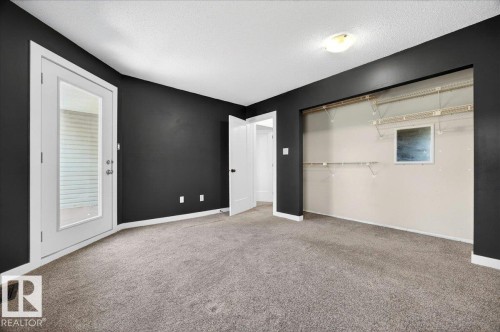 Carpeted room featuring dark accent walls and white trim - 32 1820 56 Street, Edmonton, AB - Indoor Photo Showing Other Room