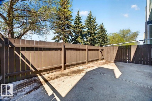 Private fenced patio area featuring a concrete surface and tall wooden privacy fencing - 32 1820 56 Street, Edmonton, AB - Outdoor