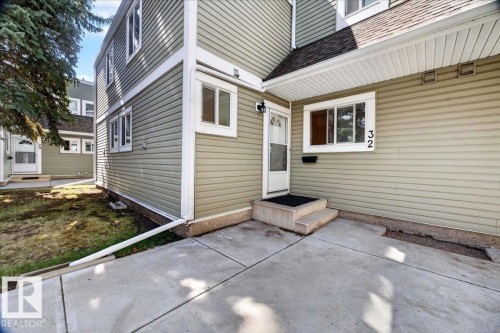 Front entry featuring a concrete walkway, two-step concrete stoop, and a white storm door - 32 1820 56 Street, Edmonton, AB - Outdoor With Exterior