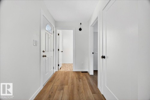 Entryway with wood-finish flooring, white walls, and a panel door featuring a decorative glass insert - 32 1820 56 Street, Edmonton, AB - Indoor Photo Showing Other Room