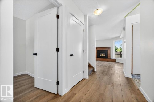 Entryway featuring wood-finish flooring, white walls, and a recessed ceiling light - 32 1820 56 Street, Edmonton, AB - Indoor Photo Showing Other Room With Fireplace