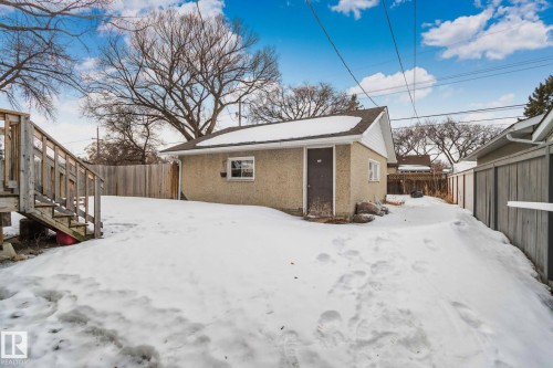 Detached garage with stucco exterior and gable roof, featuring a single window and entry door - 12002 37 Street, Edmonton, AB 