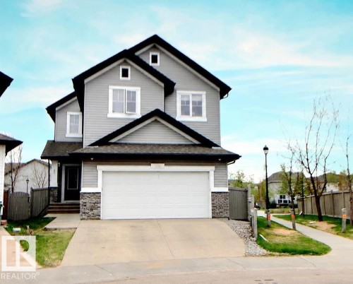 Gray two-story residence featuring a front-facing garage with a concrete driveway - 1231 37A Avenue, Edmonton, AB - Outdoor
